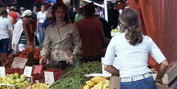 Torimyyntiä 1970_luvulla: nainen myy mm. mansikoita ja herneitä.